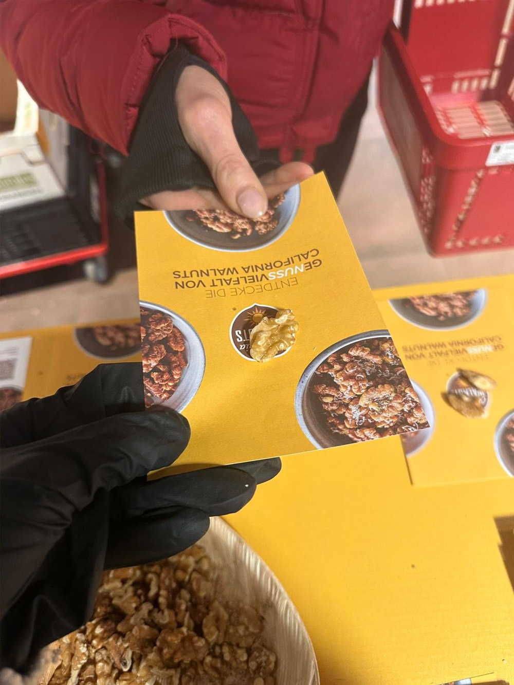 Überreichung einer Broschüre und einer Walnuss am POS-Stand